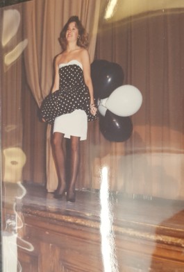 Model in black and white dress, holding black and white balloons.